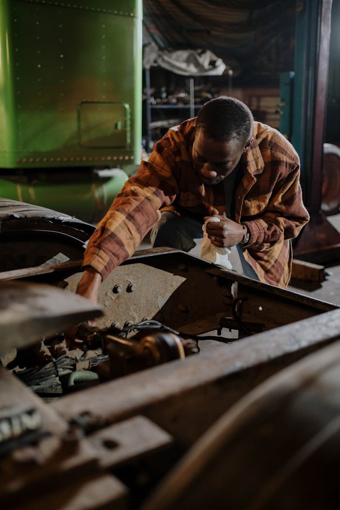 African American mechanic intensely repairing a truck in an indoor garage setting.
