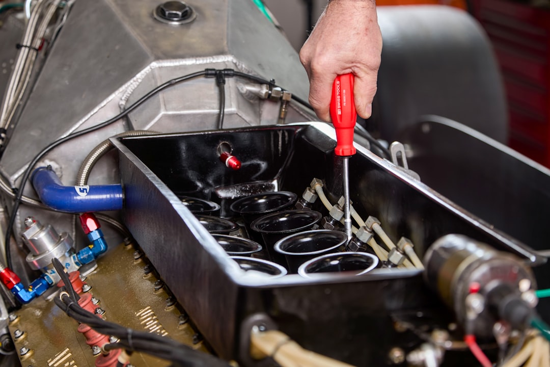 mechanic-using-a-screwdriver-on-car-engine-parts-w5tniv1kv1c